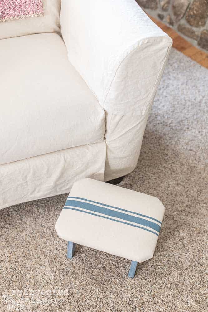 DIY footstool idea using grainsack fabric with footstool sitting next to a chair.
