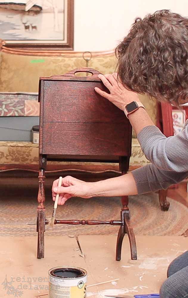 Lady applying Shellac to an antique sewing box.