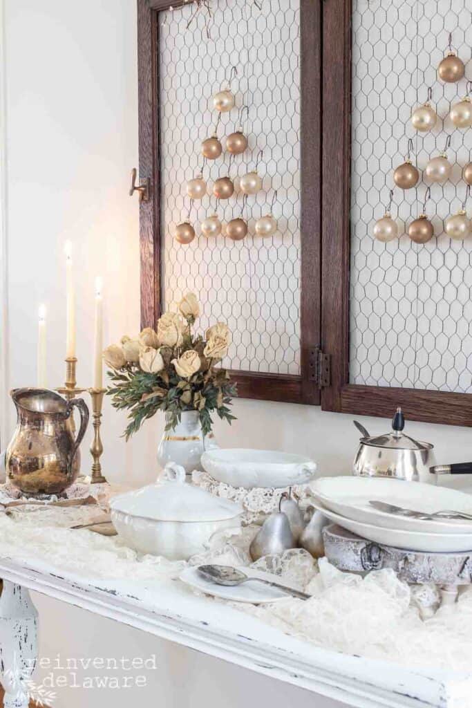 dried roses and antique ironstone soup tureens and silver pieces for a holiday table setting