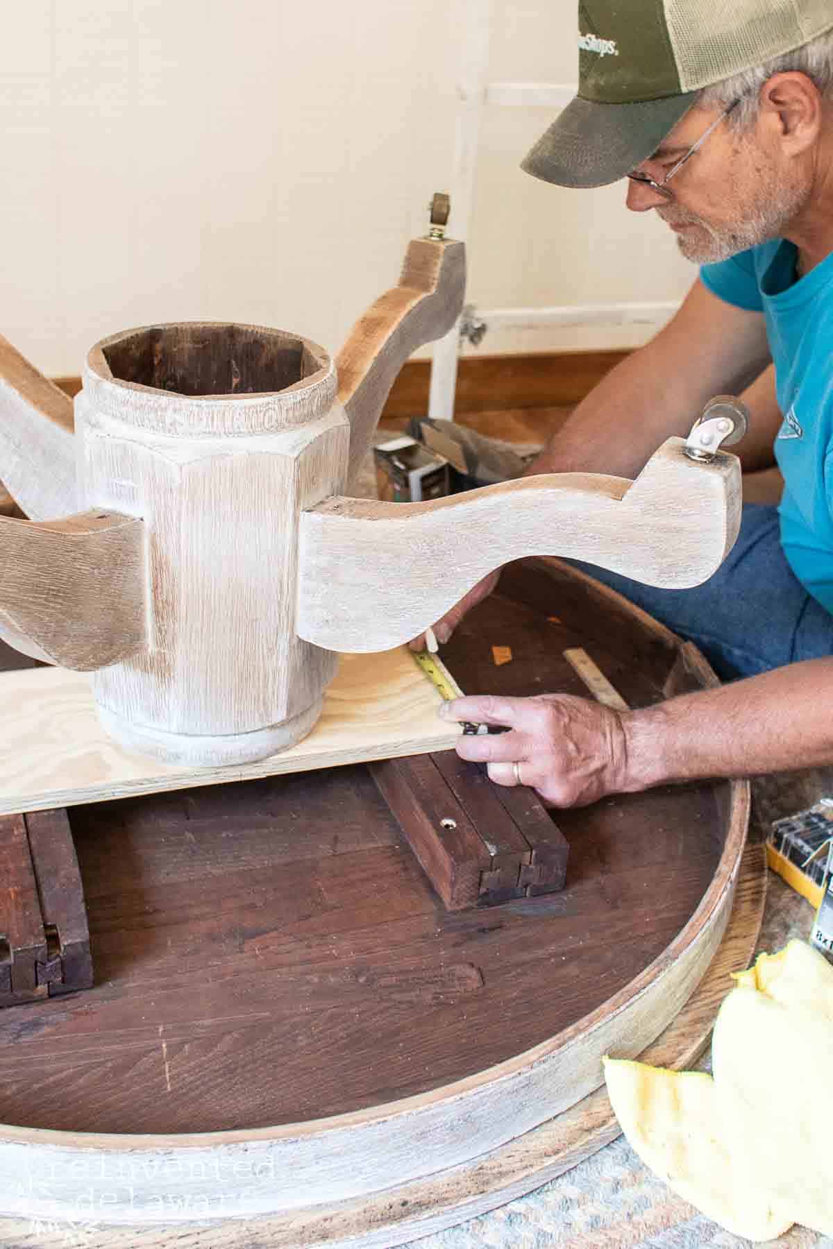 man reattaching a table base to a table top