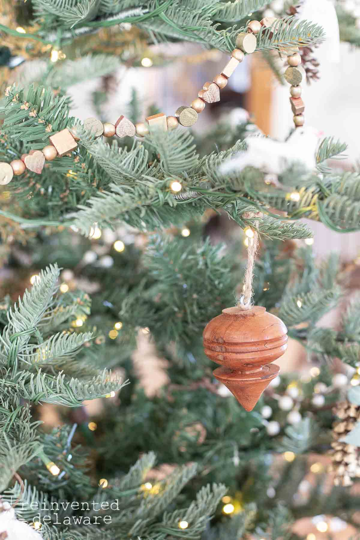 handmade wooden ornament on a simply decorated Christmas tree