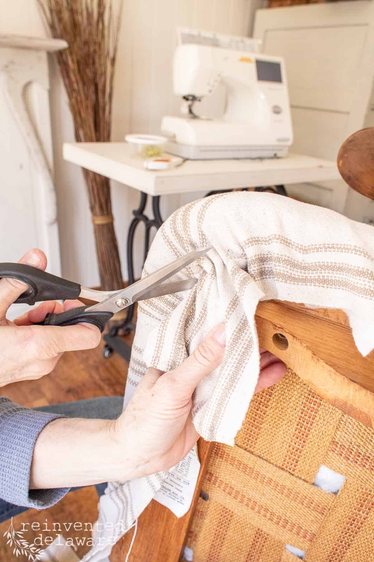 lady cutting away excess fabric on an upholstery project