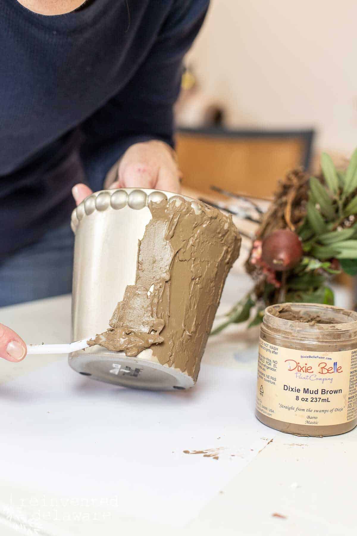 applying textured wood filler to pot to create a faux finish