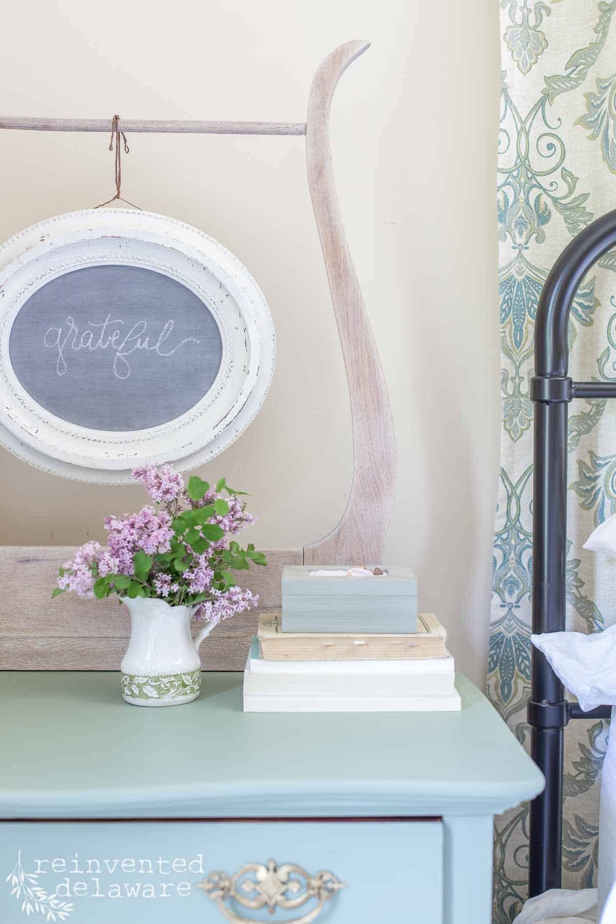 lilac blooms in an ironstone pitcher on top of an antqiue washstand