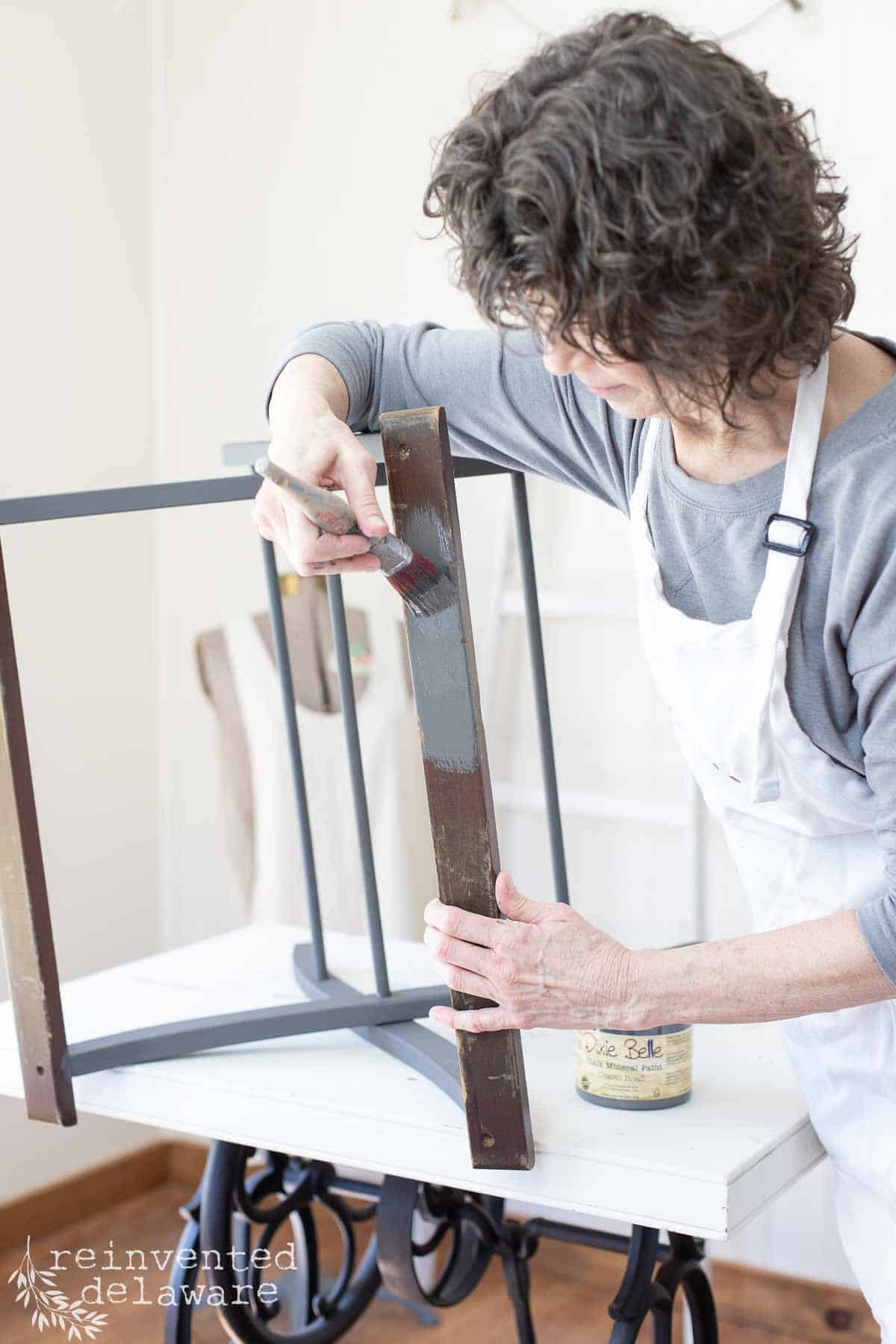 lady painting an old luggage rack for a makeover