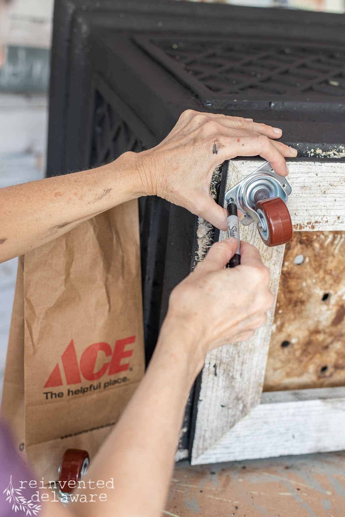 lady attaching casters to the bottom of heavy outdoor planter