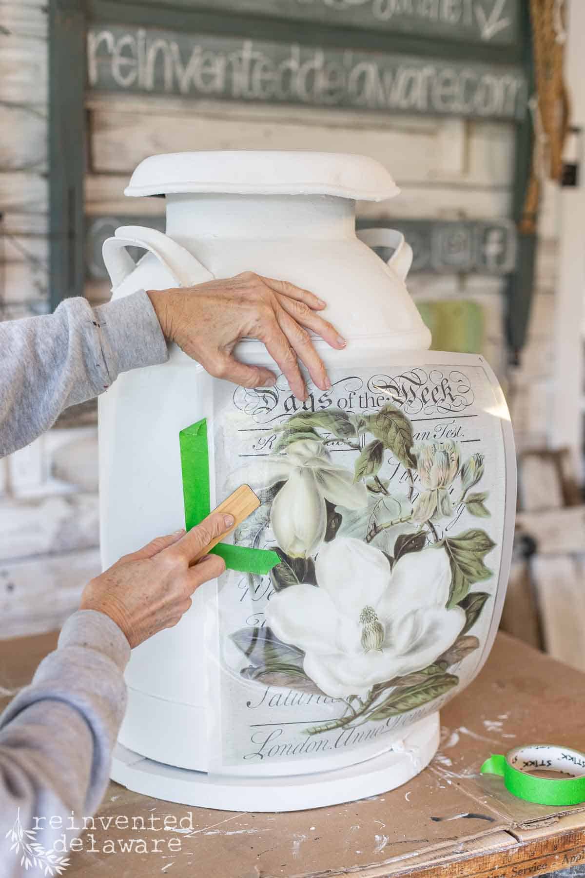 lady applying a transfer on an old milk can