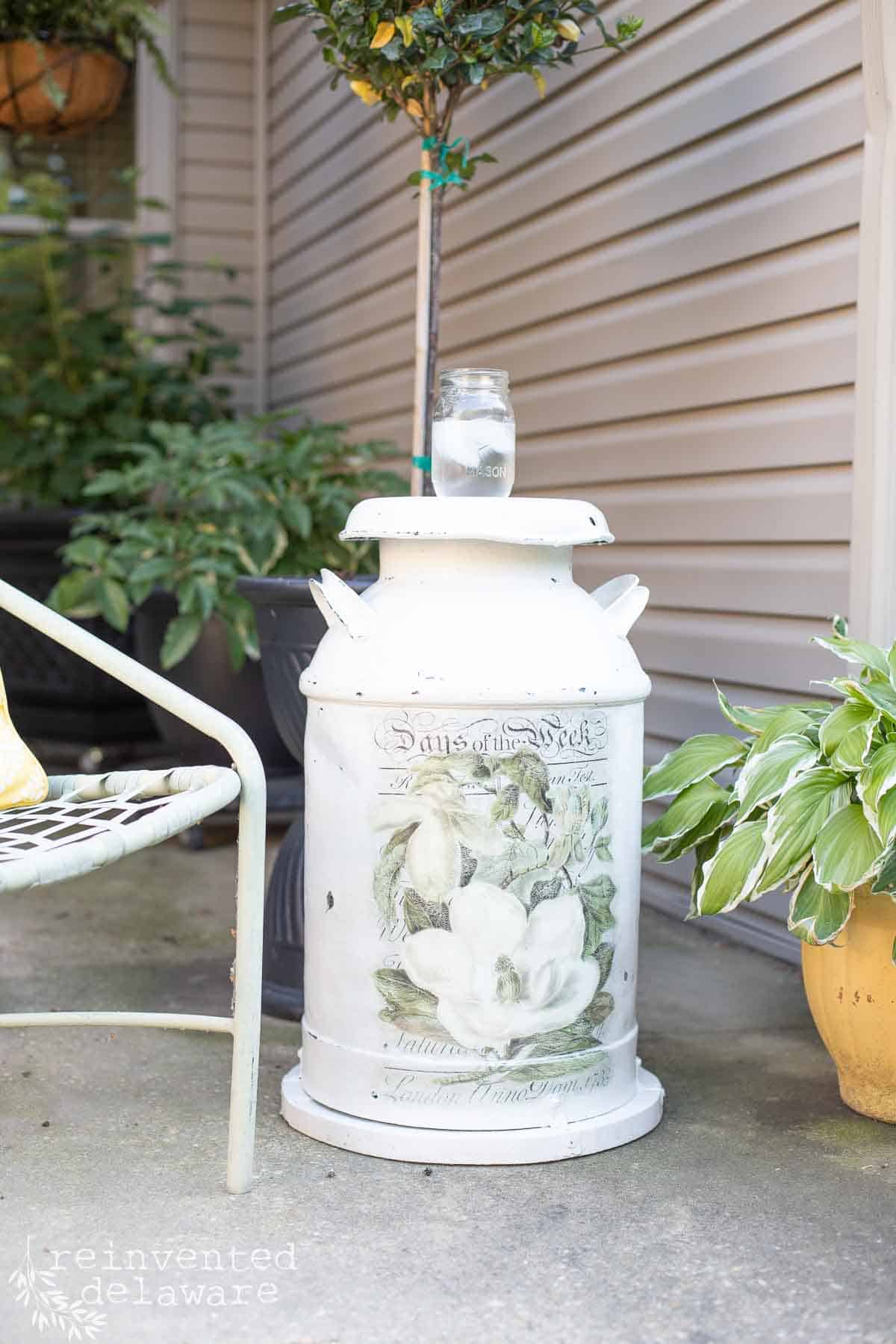 repurposed antique milk can on an outdoor patio