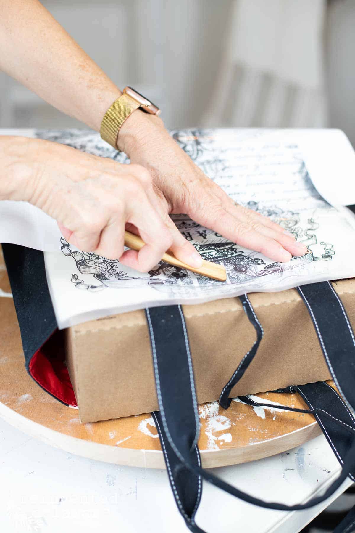 lady applying a transfer to a sustainable tote bag project