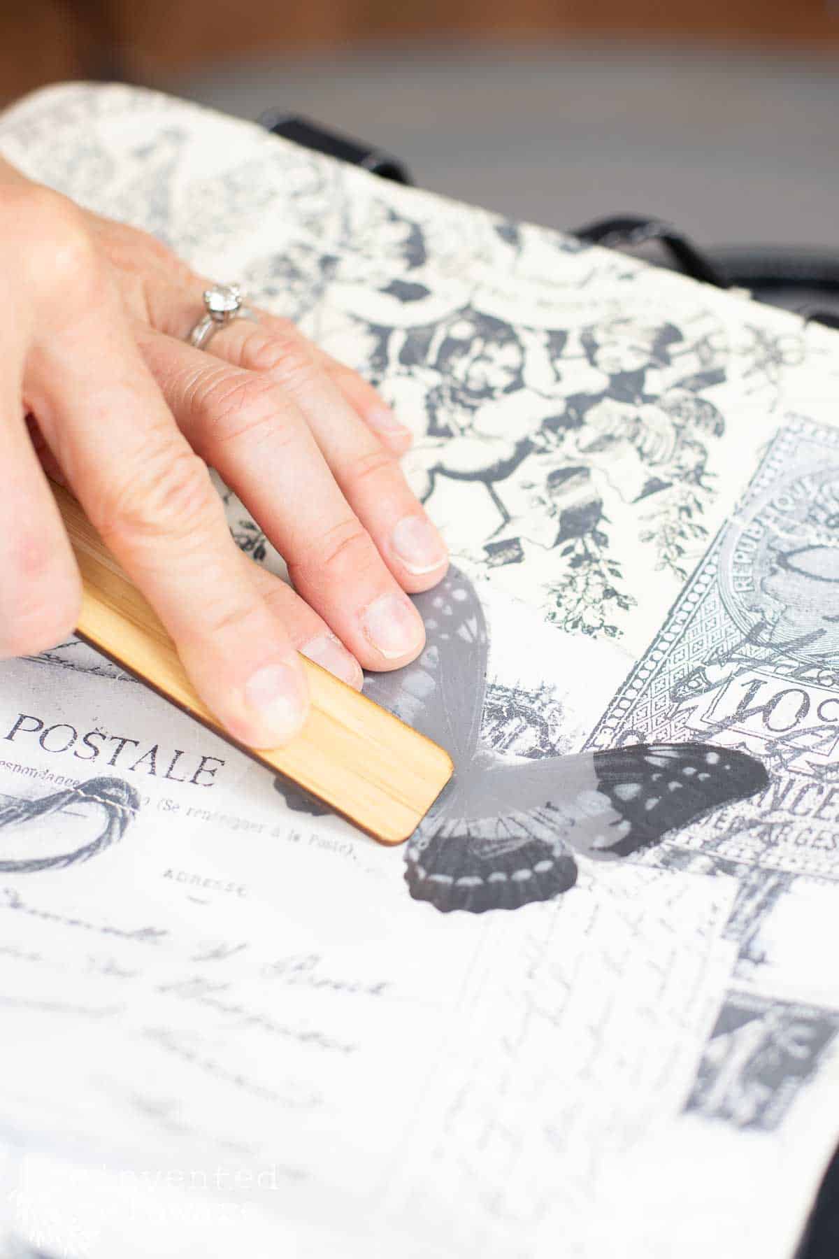 lady applying a decorative transfer to fabric tote bag