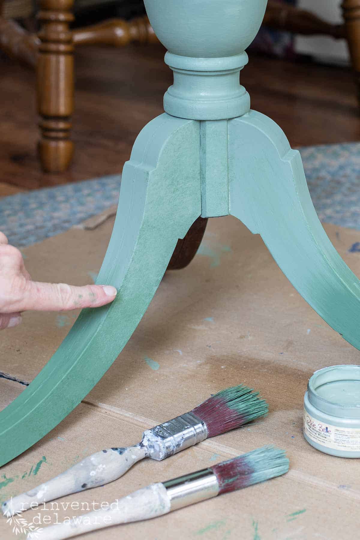 lady showing how to blend chalk paint on a furniture piece