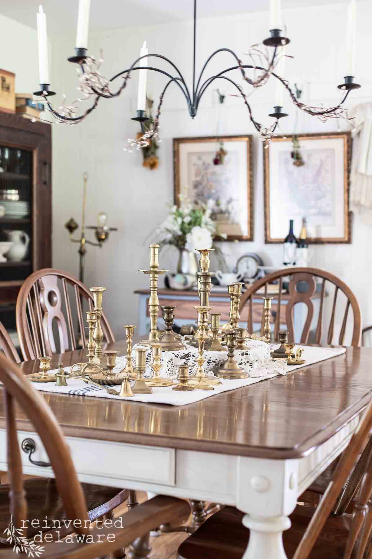 grouping of many real brass candlesticks on a dining table
