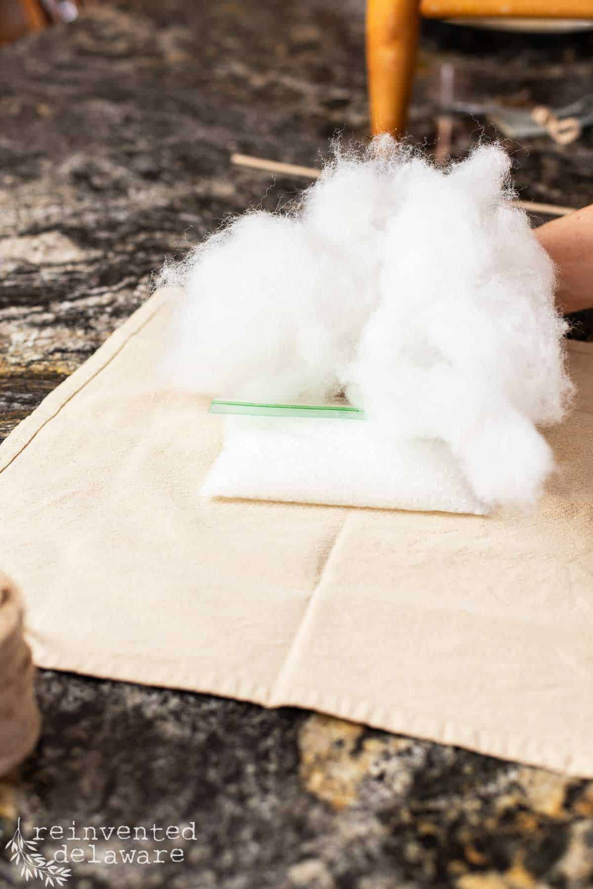 lady adding stuffing and poly pellets to fabric for pumpkin craft
