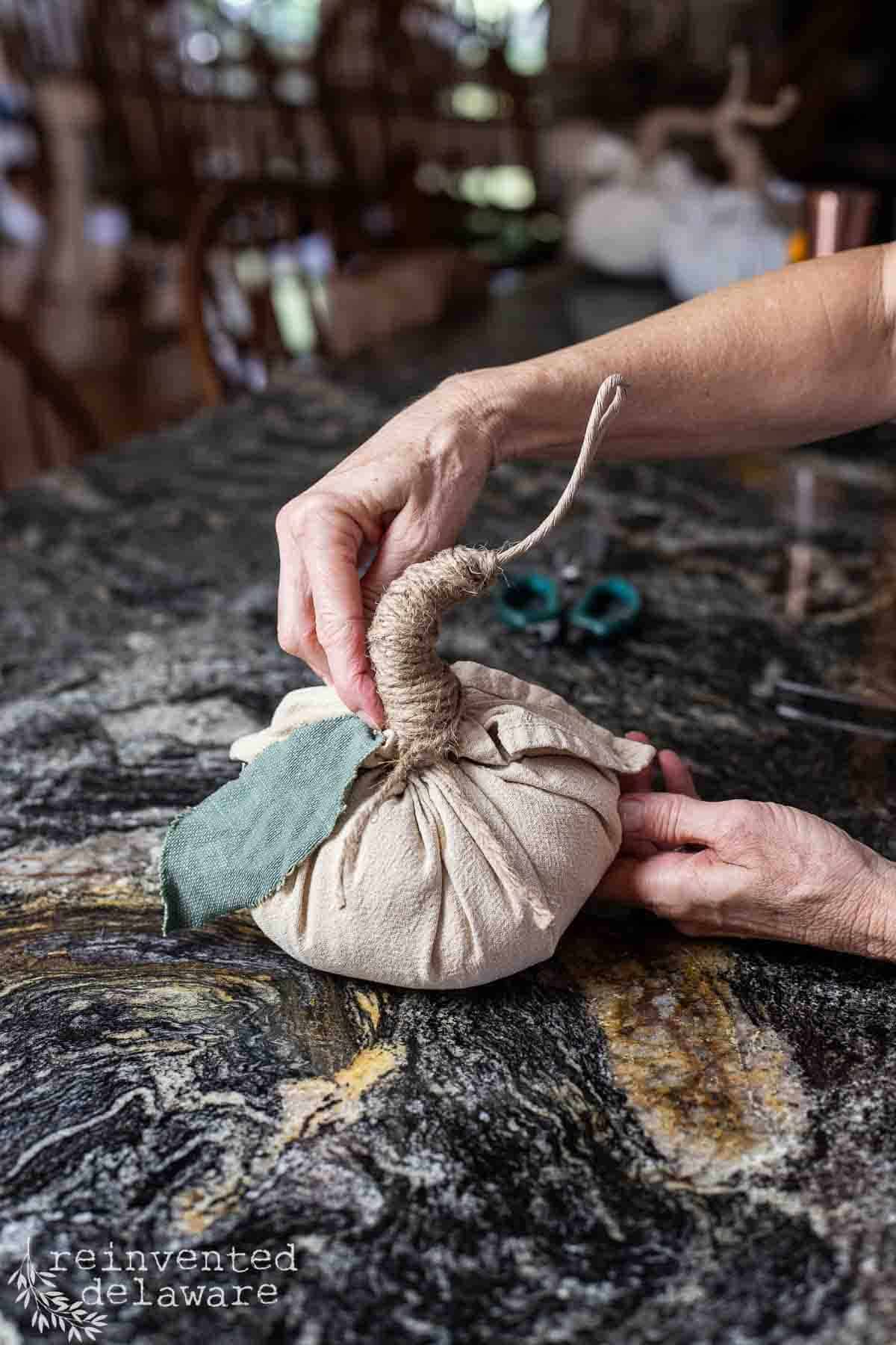 lady making a small pumpkin for a fall craft