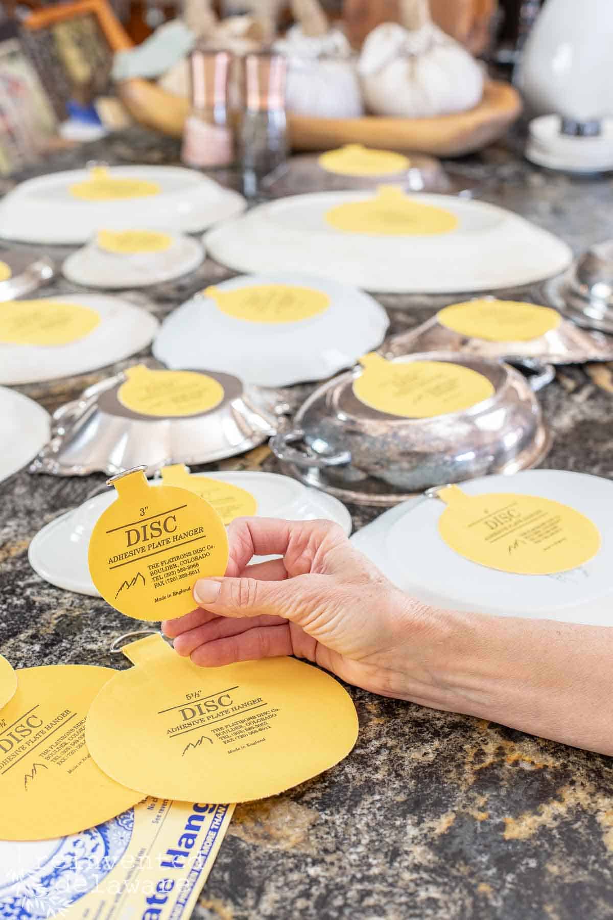 lady showing adhesive disc plate hangers
