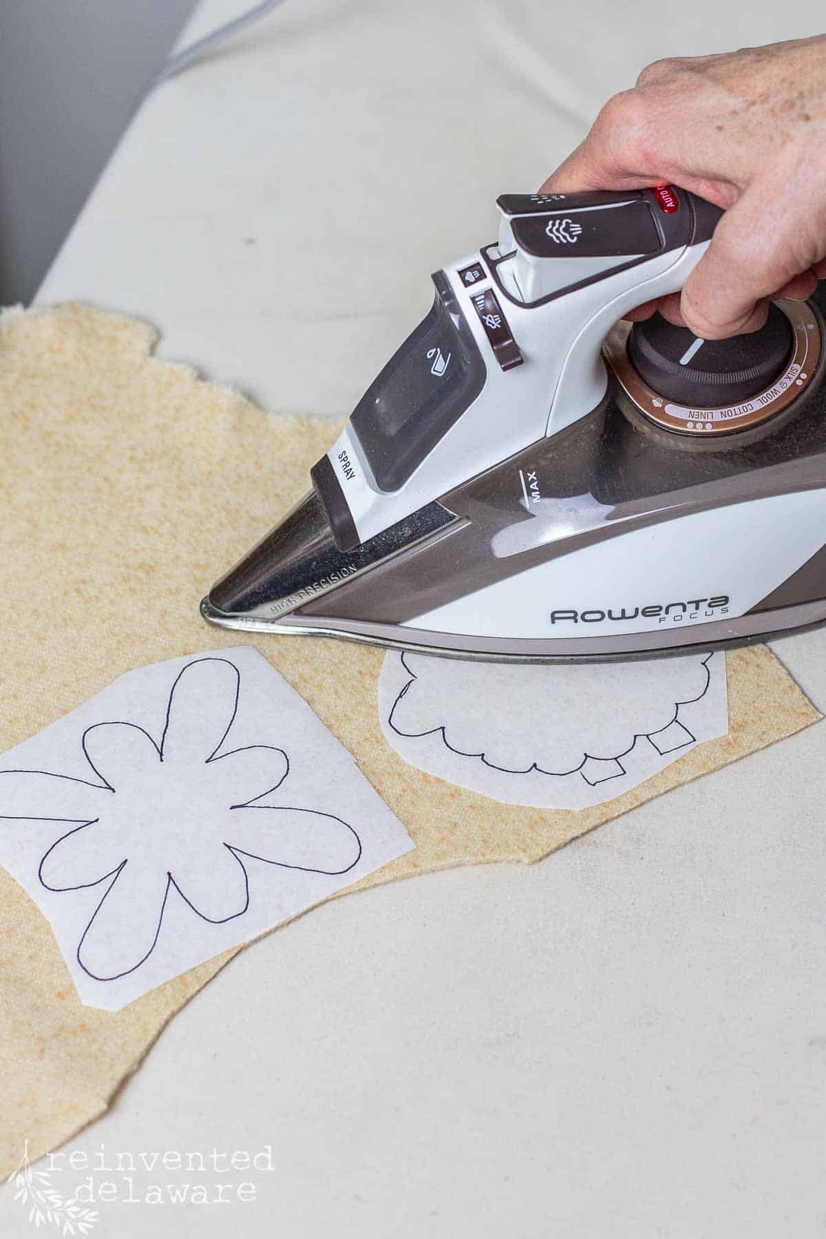 lady applying iron on adhesive for a diy ornament