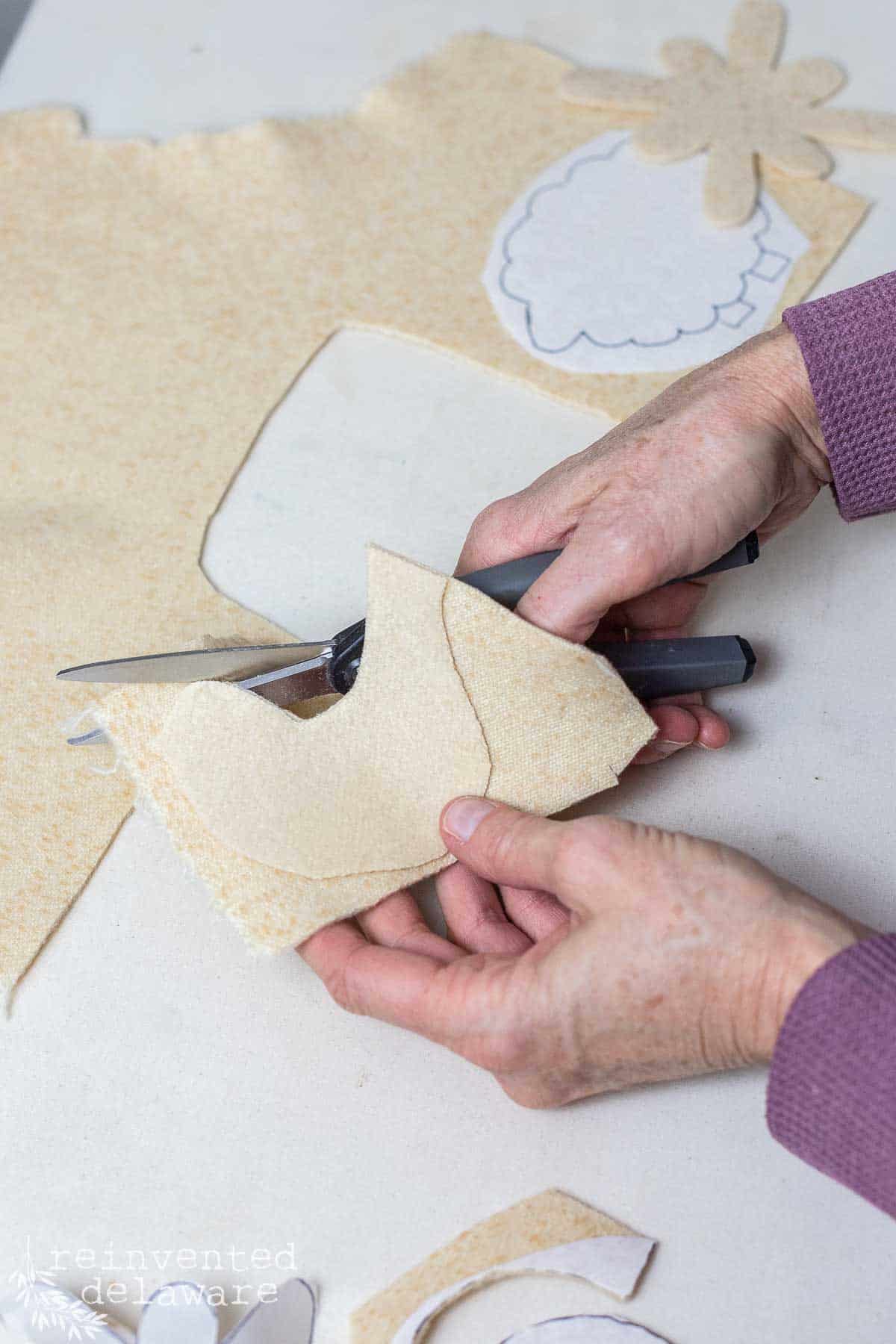 lady cutting out a pattern for a handmade felt ornament