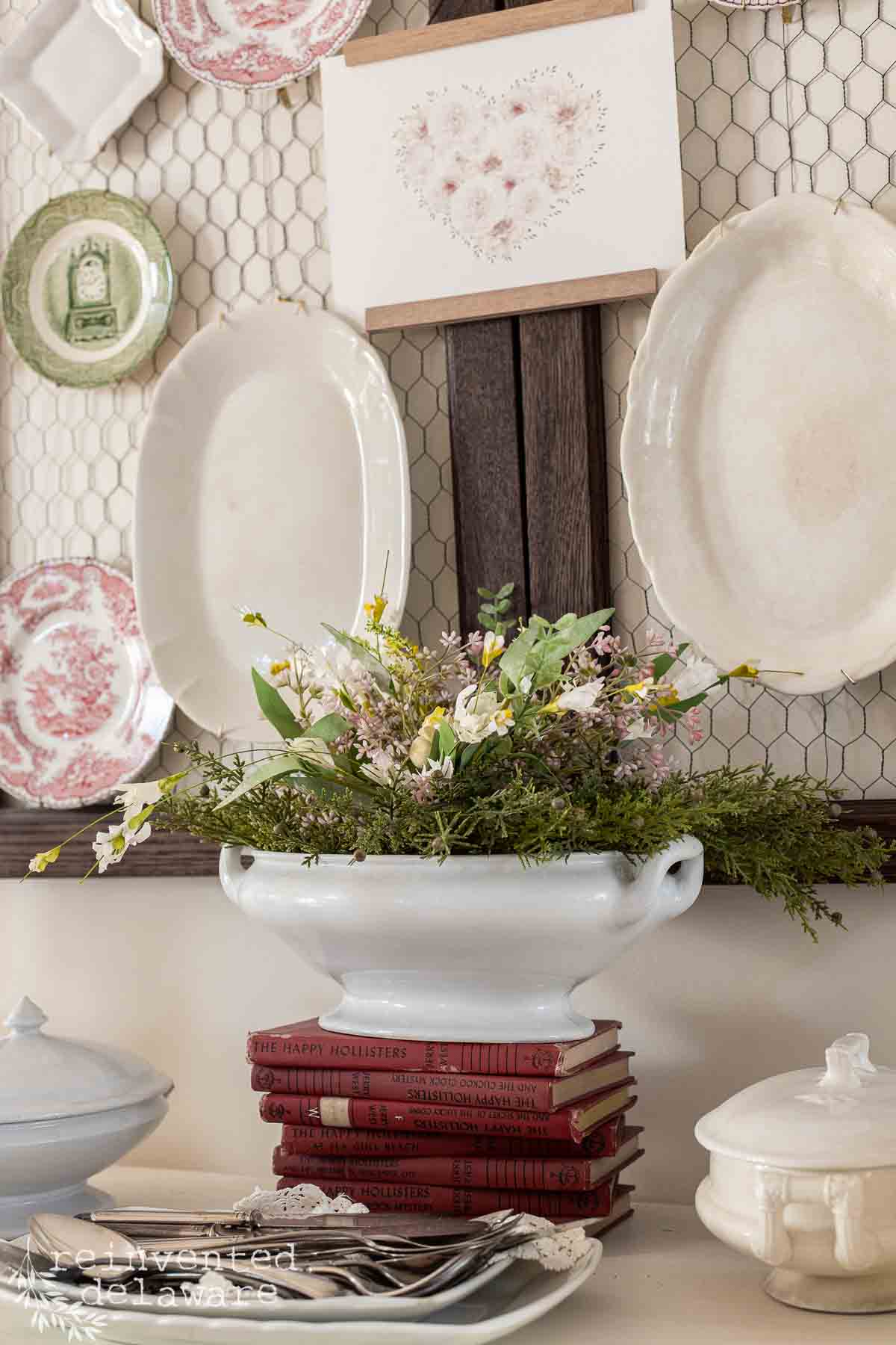 ironstone dishes hanging on a wall as decor and ironstone soup toureen with Valentine's Day floral arrangement