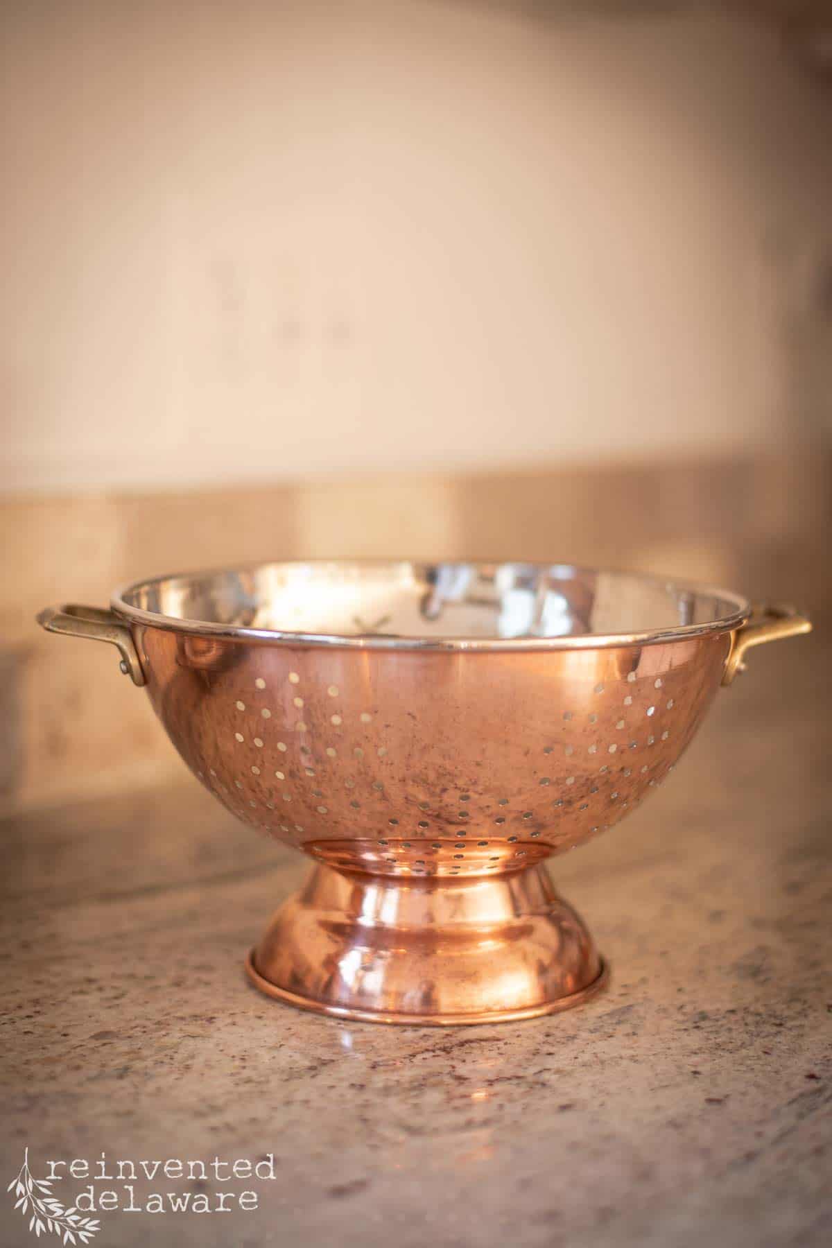 polished copper strainer that was tarnished and is now clean