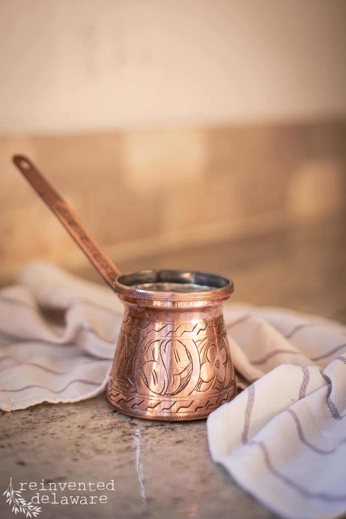 small copper Turkish coffee maker that has been polished to a shine