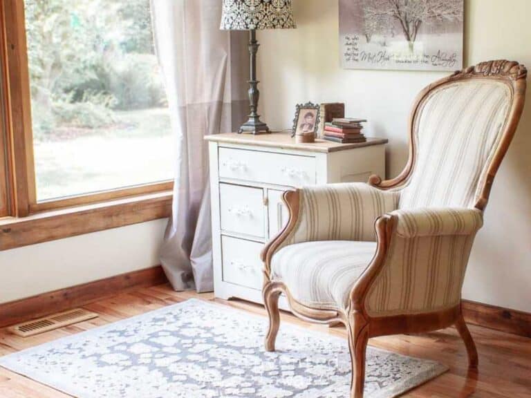 reupholsterd Victorian chair in grain sack fabric staged with an antique washstand in a guest room