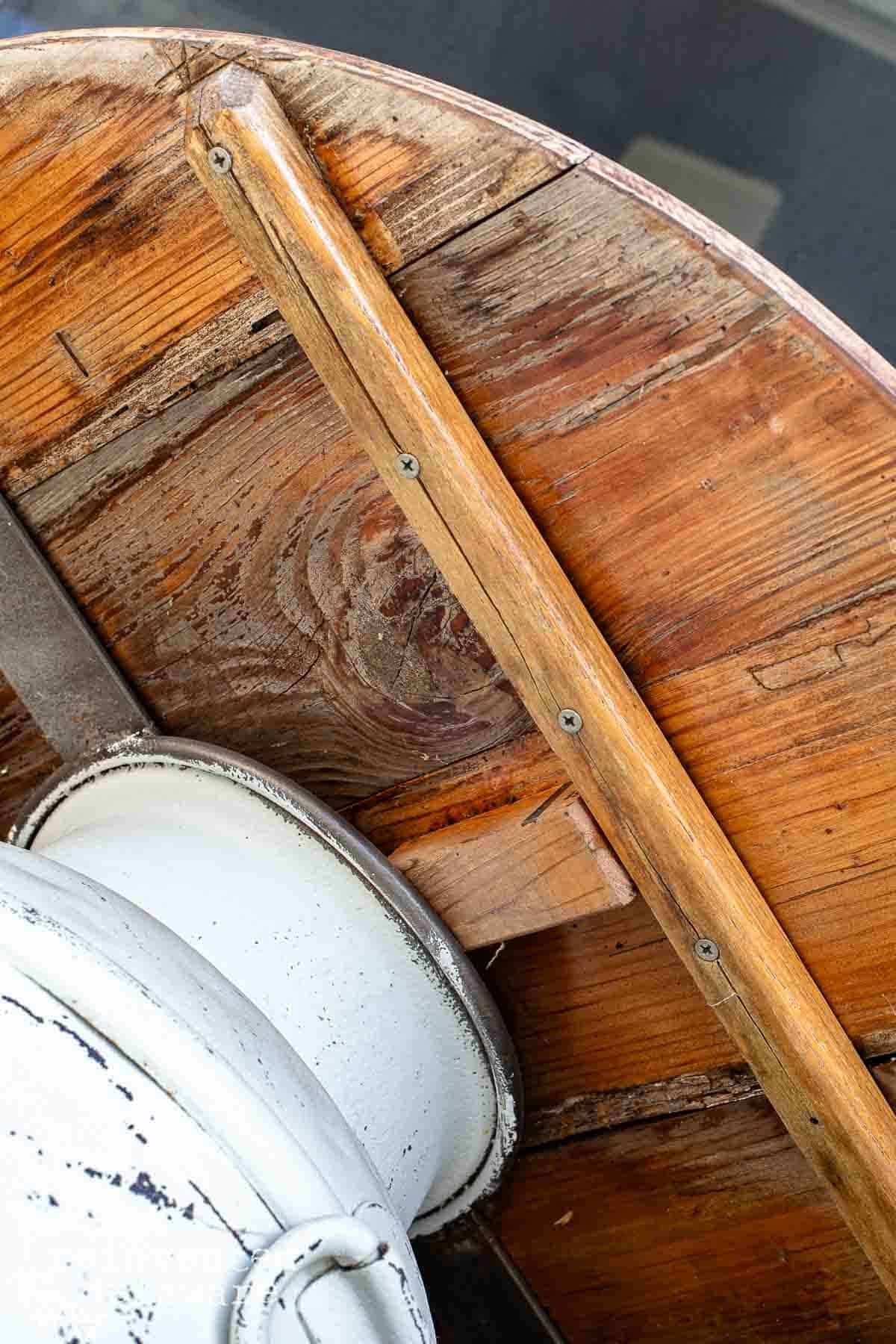 underside of old milk can table makeover using a wood round secured to a vintage milk can