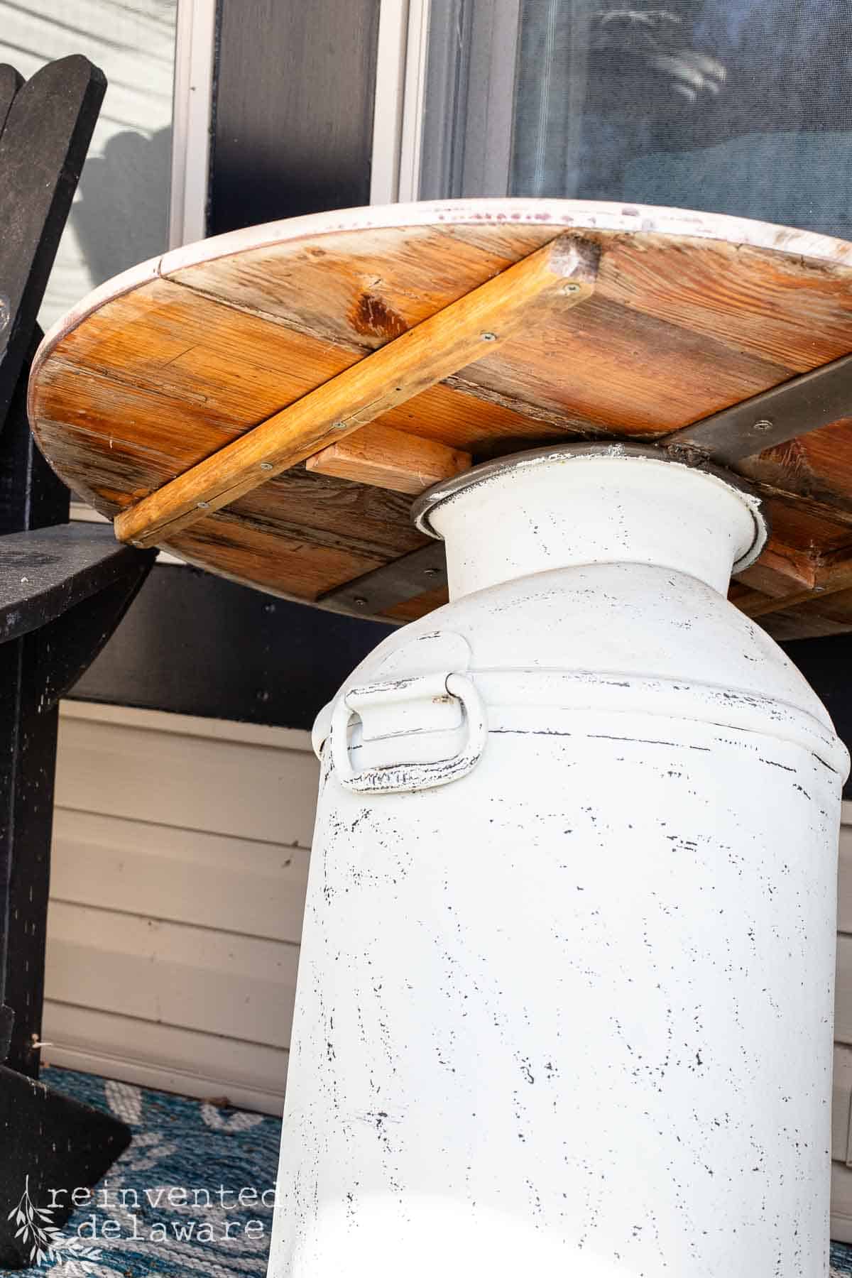 wood round piece attached to an antique milk can to create a diy side table