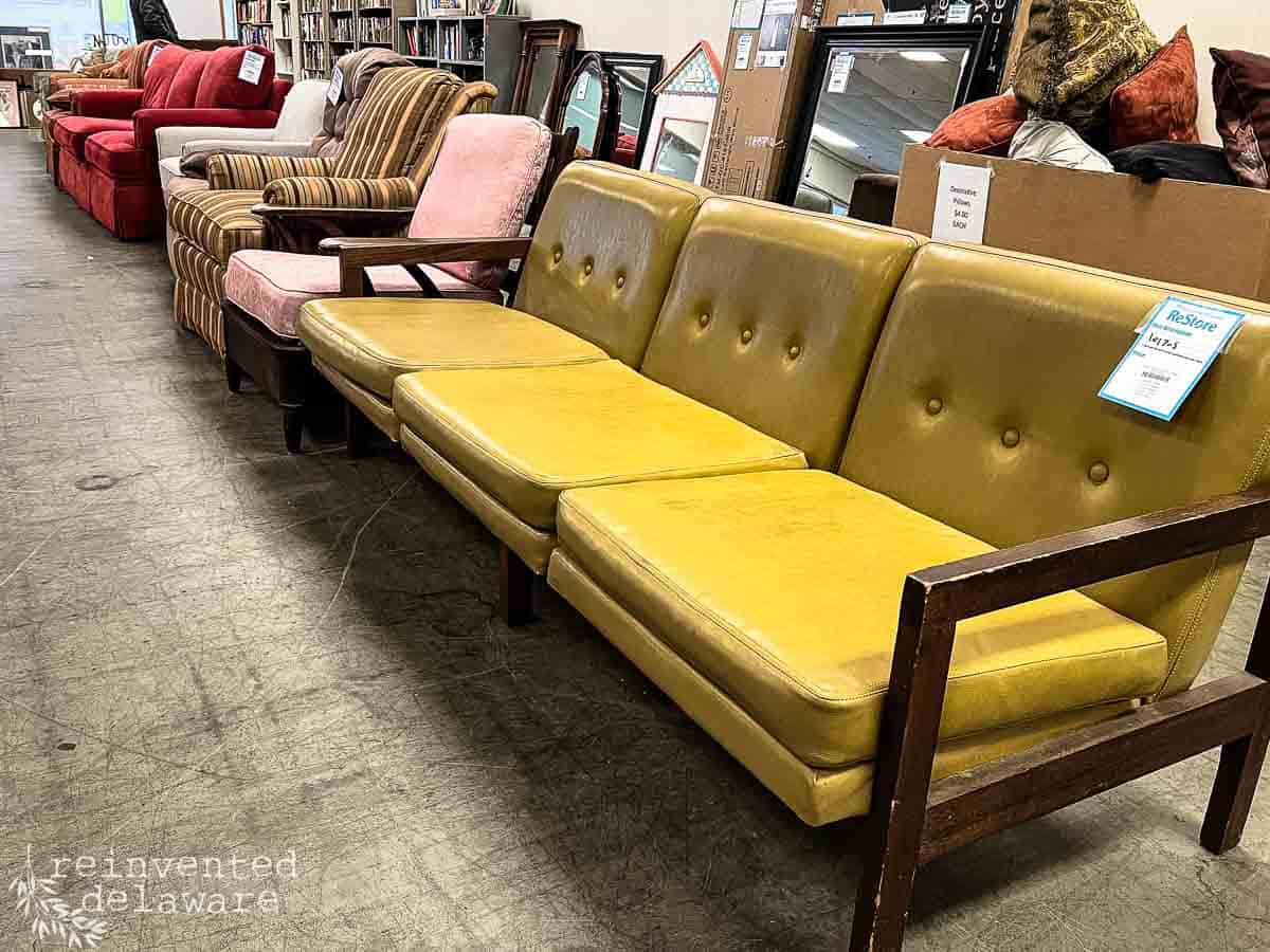 used furniture at a Restore retail store including a mid century modern yellow sofa and chairs