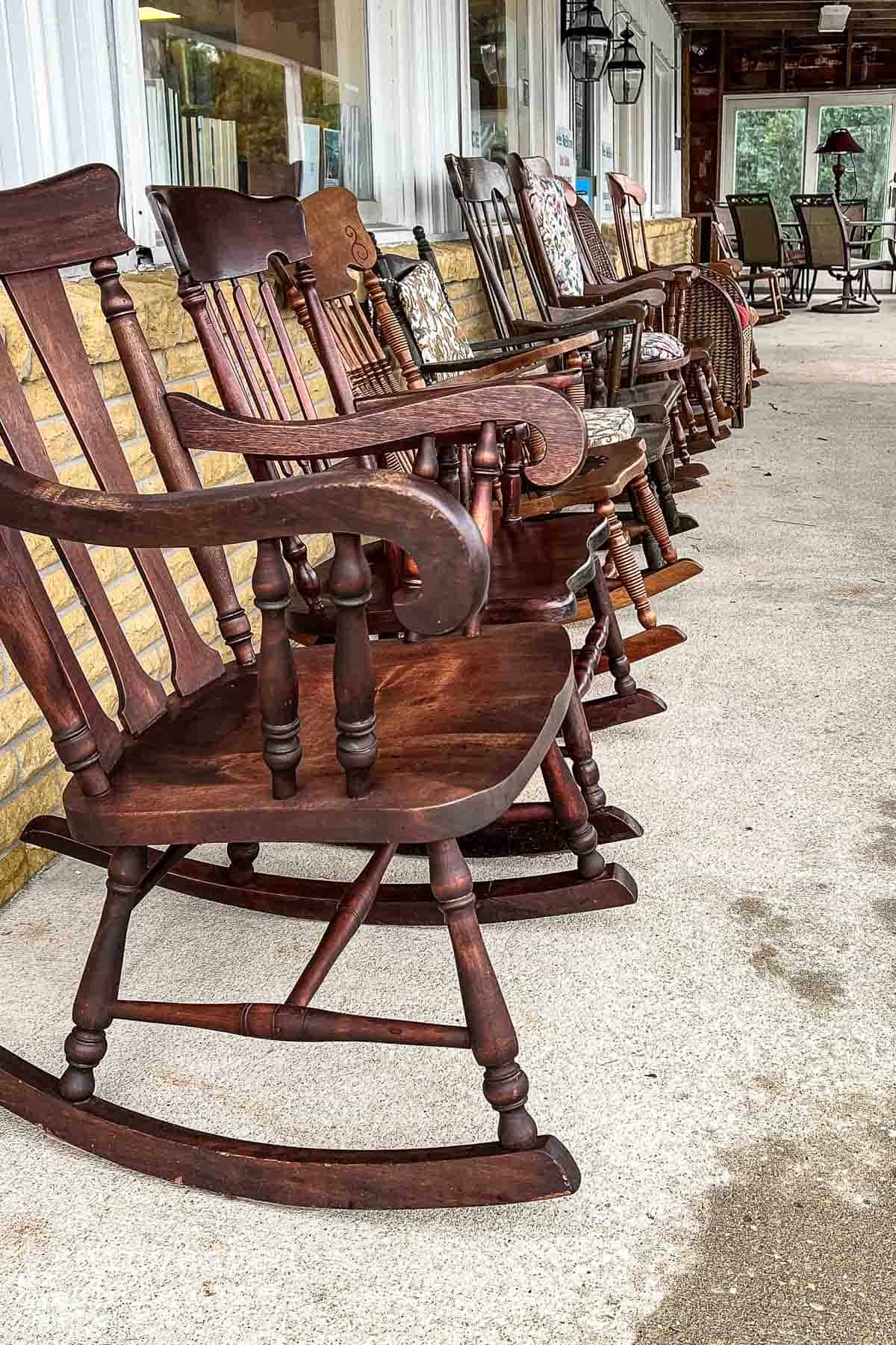 a row of antique used rocking chairs in front of a Restore retail store