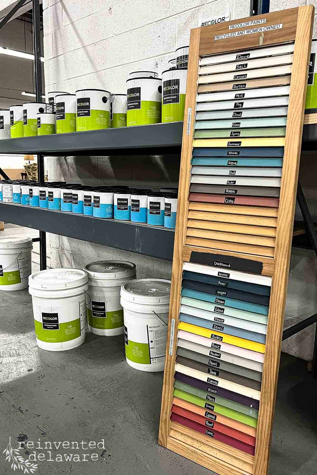 a store display with paint and supplies and a color chart painted on an old shutter in a Restore