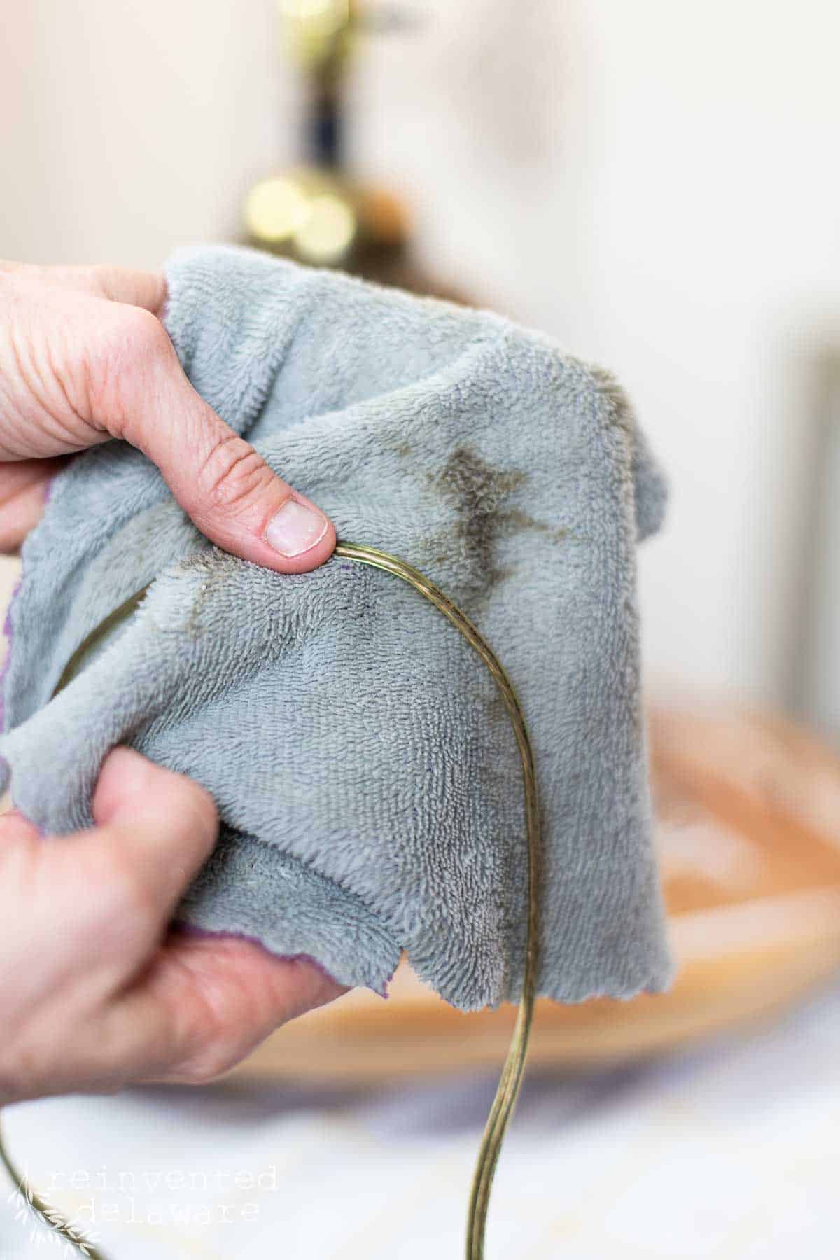 Lady showing how to clean a thrift store lamp cord to remove the grime.