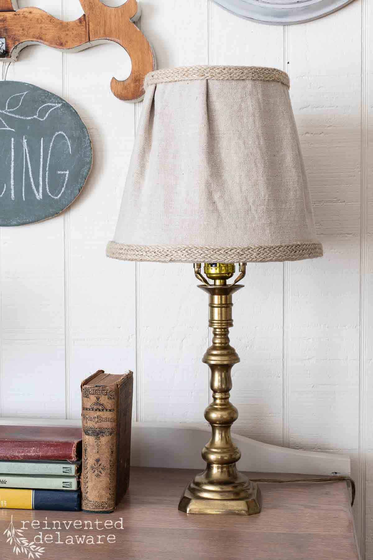 Old lamp that has been upcycled by waxing the brass lamp base and a new pleated shade made from linen.