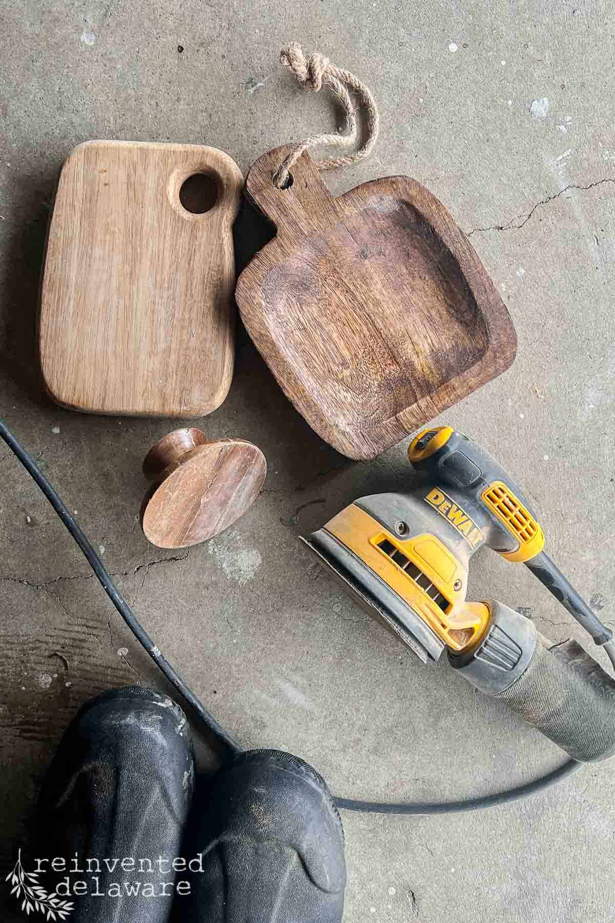 thrift store wooden cutting boards, bowls and kitchen utensils being sanded for a makeover