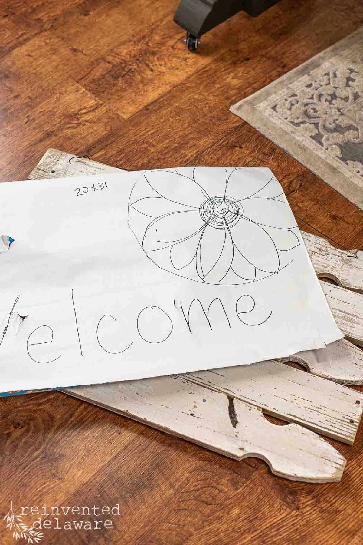 sketch desgin for a porch welcome sign with a sunflower and the word welcome drawn on the front