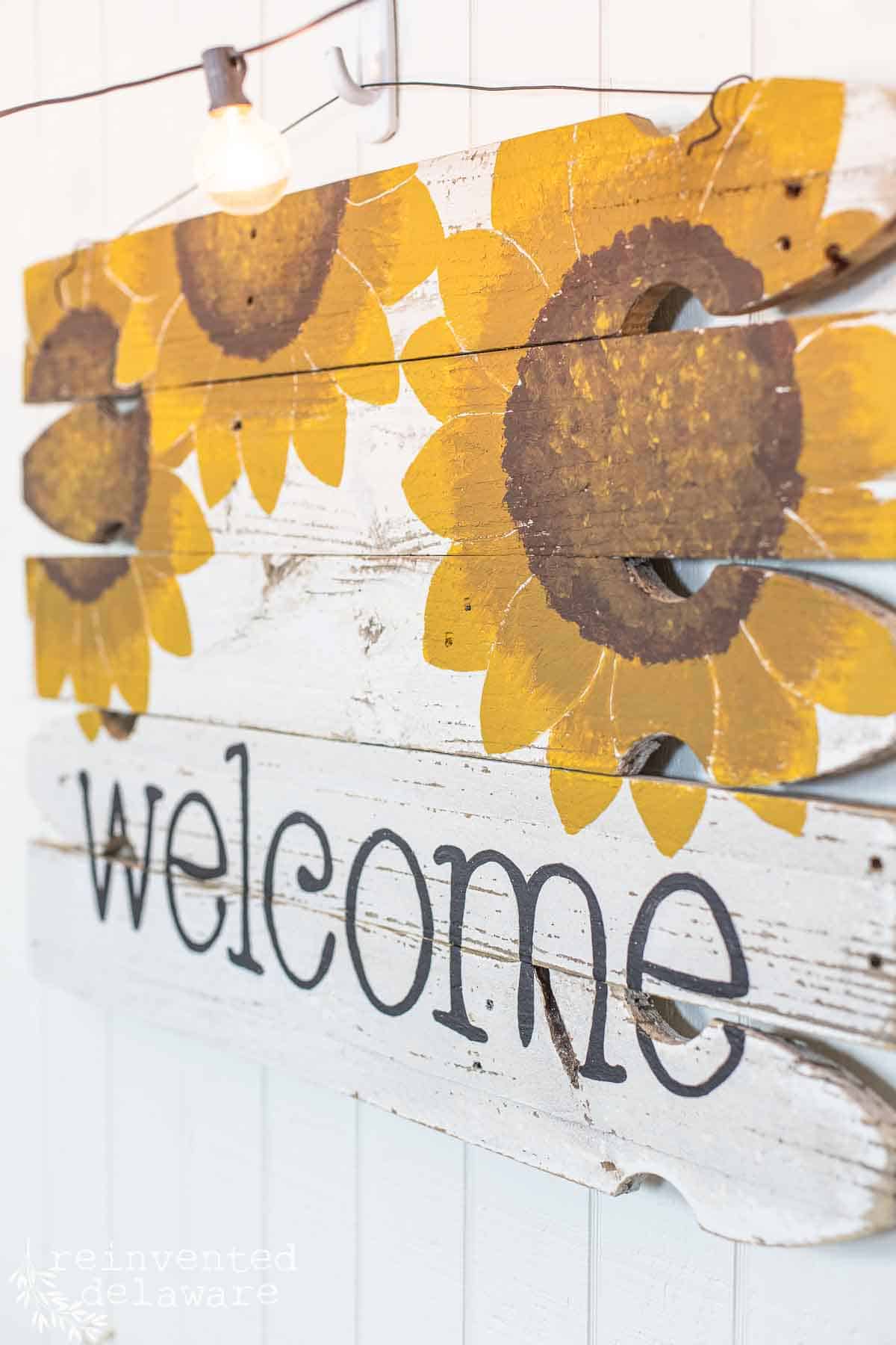 handmade porche welcome sign diy project with painted sunflowers and the word welcome painted on the bottom