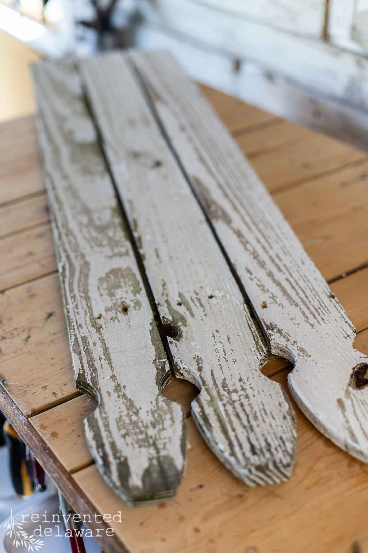 Three reclaimed wood fence boards attached to build an outdoor wood flag.