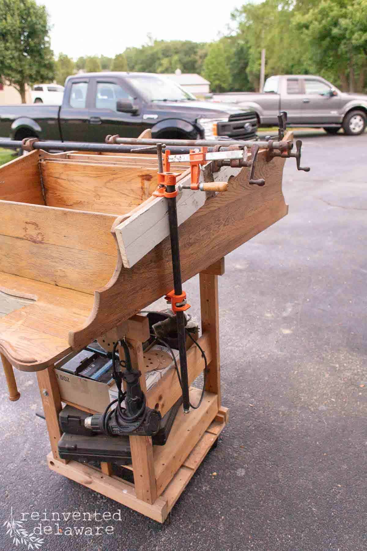 An old oak secretary desk with furniture clamps and wood glue to make needed repairs.