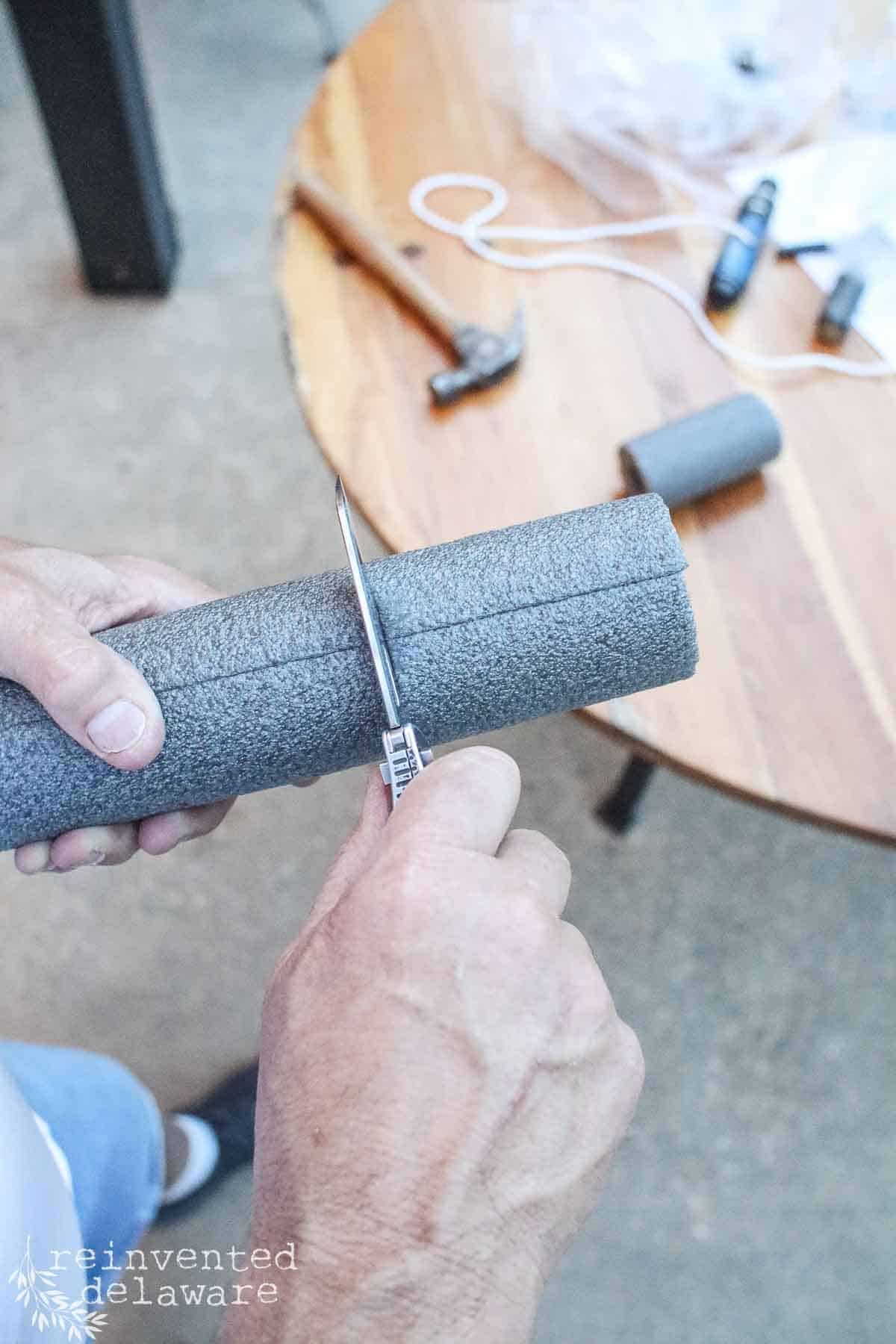 Man cutting foam with a sharp tool.