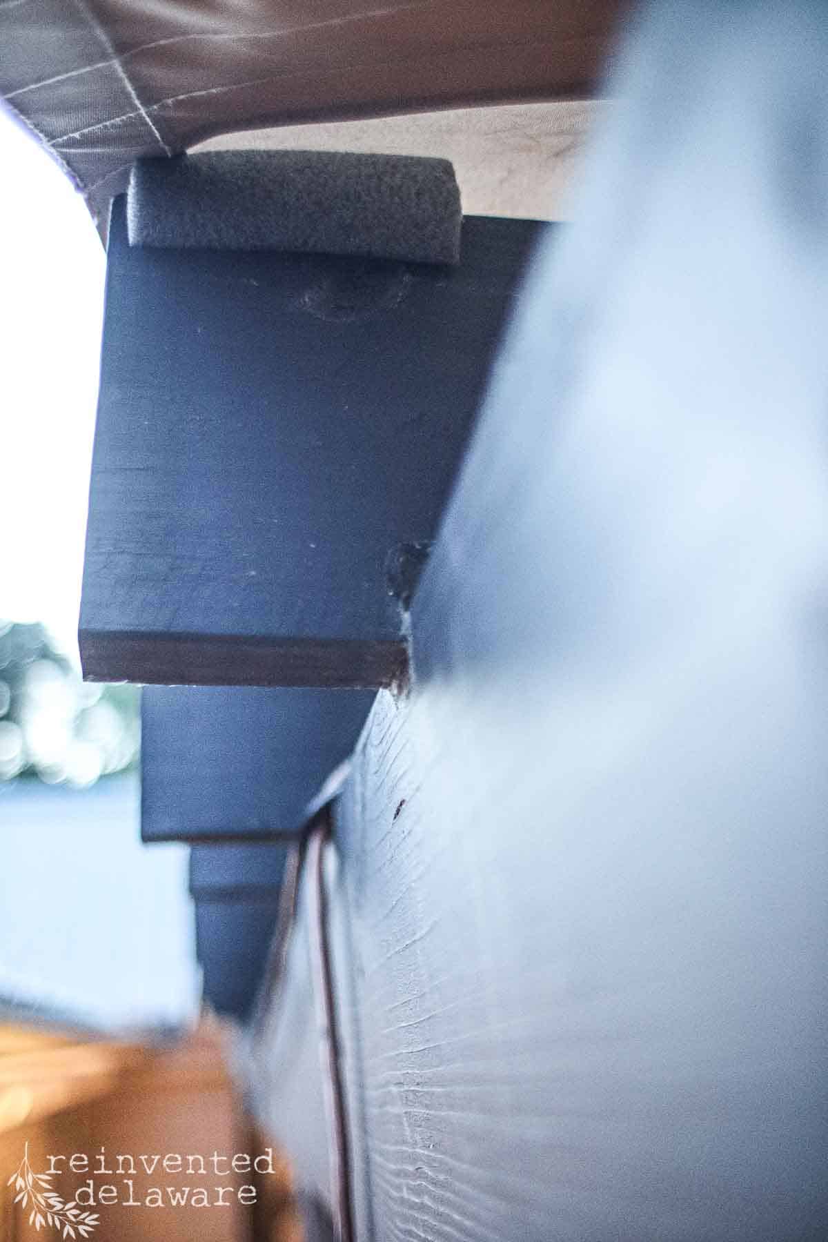 Underside of a wood pergola with a sun shade installed on top of it.