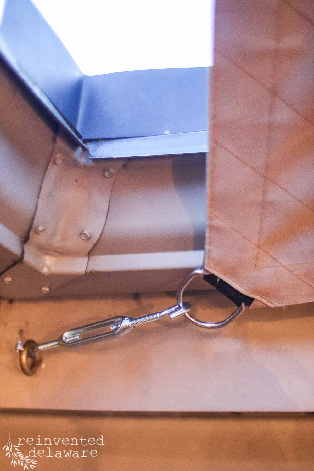 Close up of hardware used to secure a diy sun shade to a home.