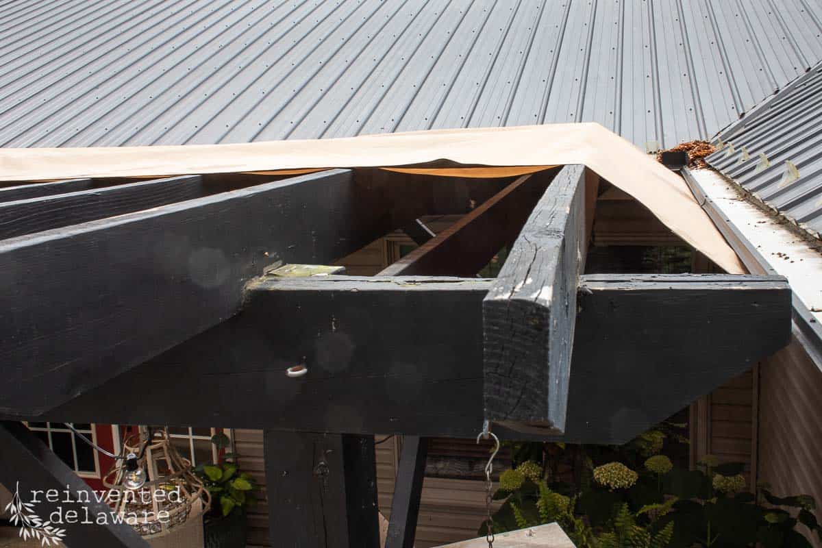 Top of wood pergola showing how a diy sun shade was installed to provide shade for an area below.