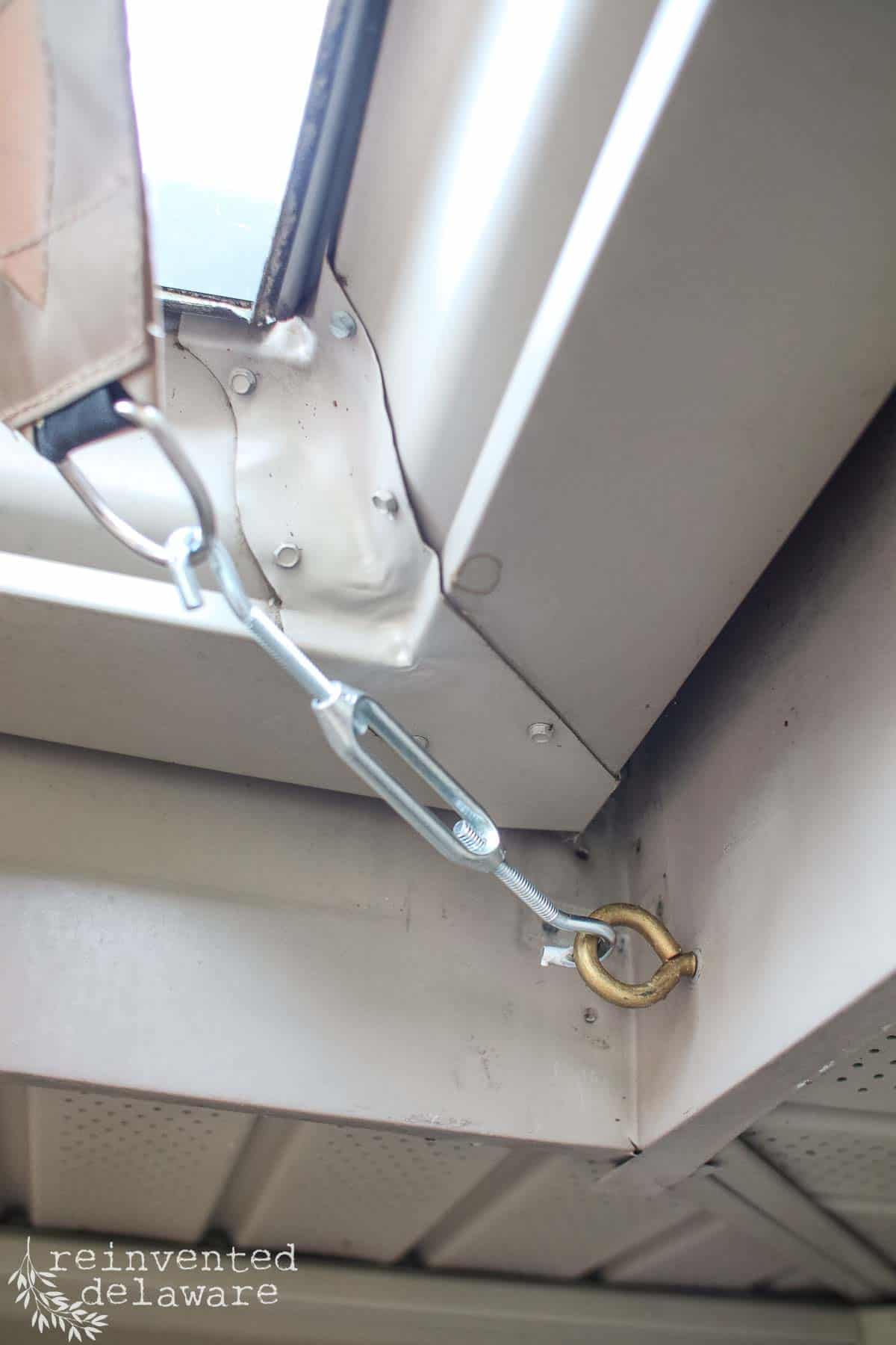 Hardware used to attach an outdoor sun shade sail to the exterior of a home to provide shade for a patio.