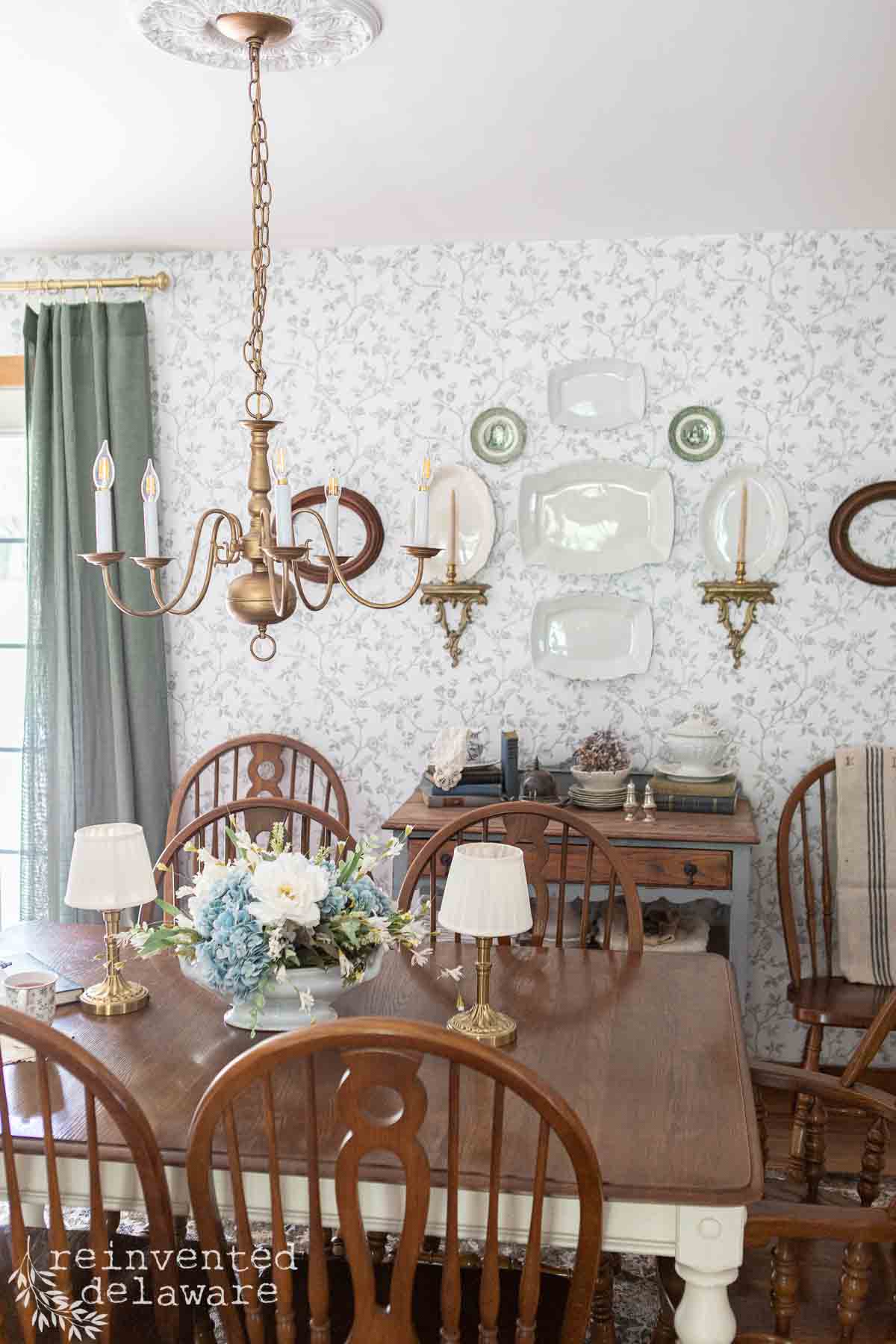 Elegant vintage dining room with wooden table, chandelier, and floral accents.