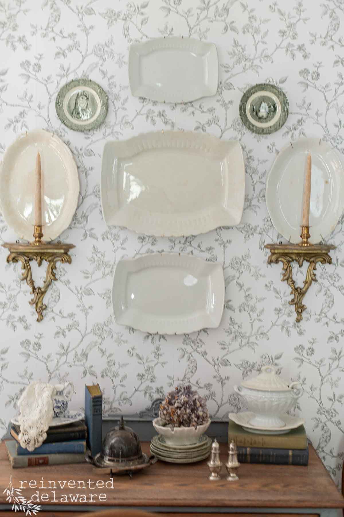 Elegant vintage wall display with plates, candles, and decorative items in a historic Delaware home.