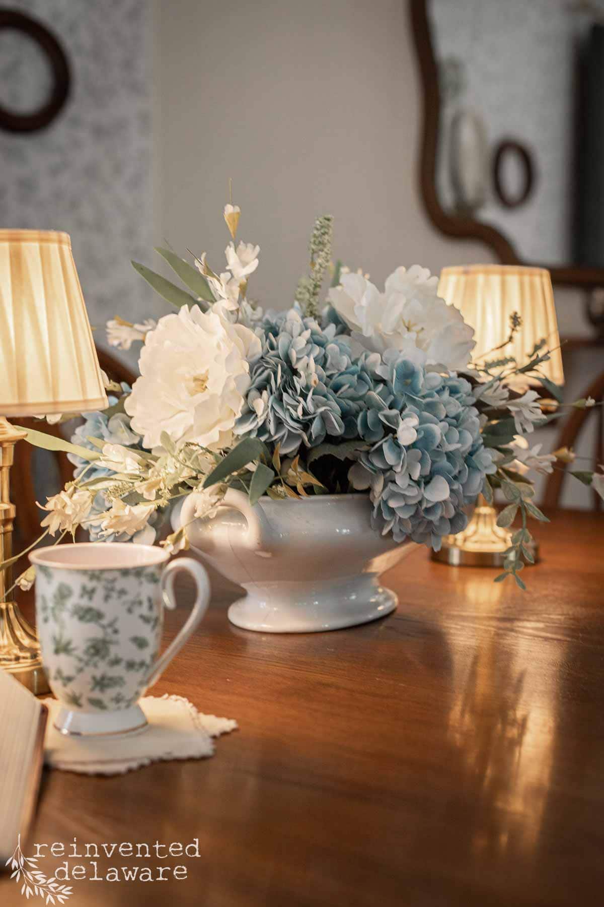 Beautiful floral centerpiece featuring white and blue hydrangeas and peonies in a classic white vase.